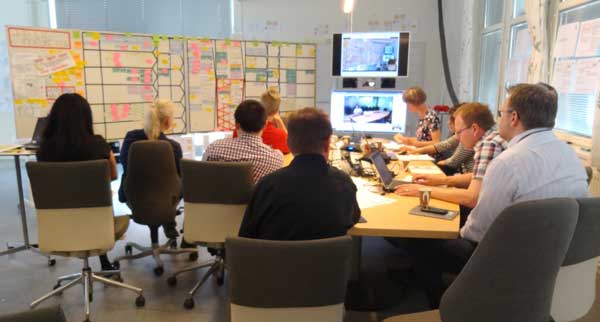 Figure 2 — Visualization room with key stakeholders and videoconference link to other sites.