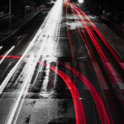 Wet road with reflected red lane marks of a fork in the road