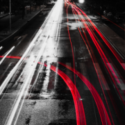 Wet road with reflected red lane marks of a fork in the road 