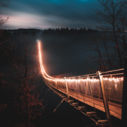 lit up brown pedestrian suspension bridge at night