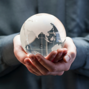 closeup of hands holding glass globe sculpture