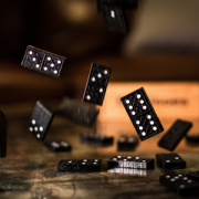 four black dominoes bouncing off a tabletop
