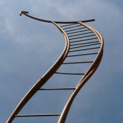 Twisting metal ladder reaching toward sky with metal arrow pointing upwards on top rung