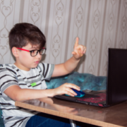 young boy interacting with lesson on laptop 